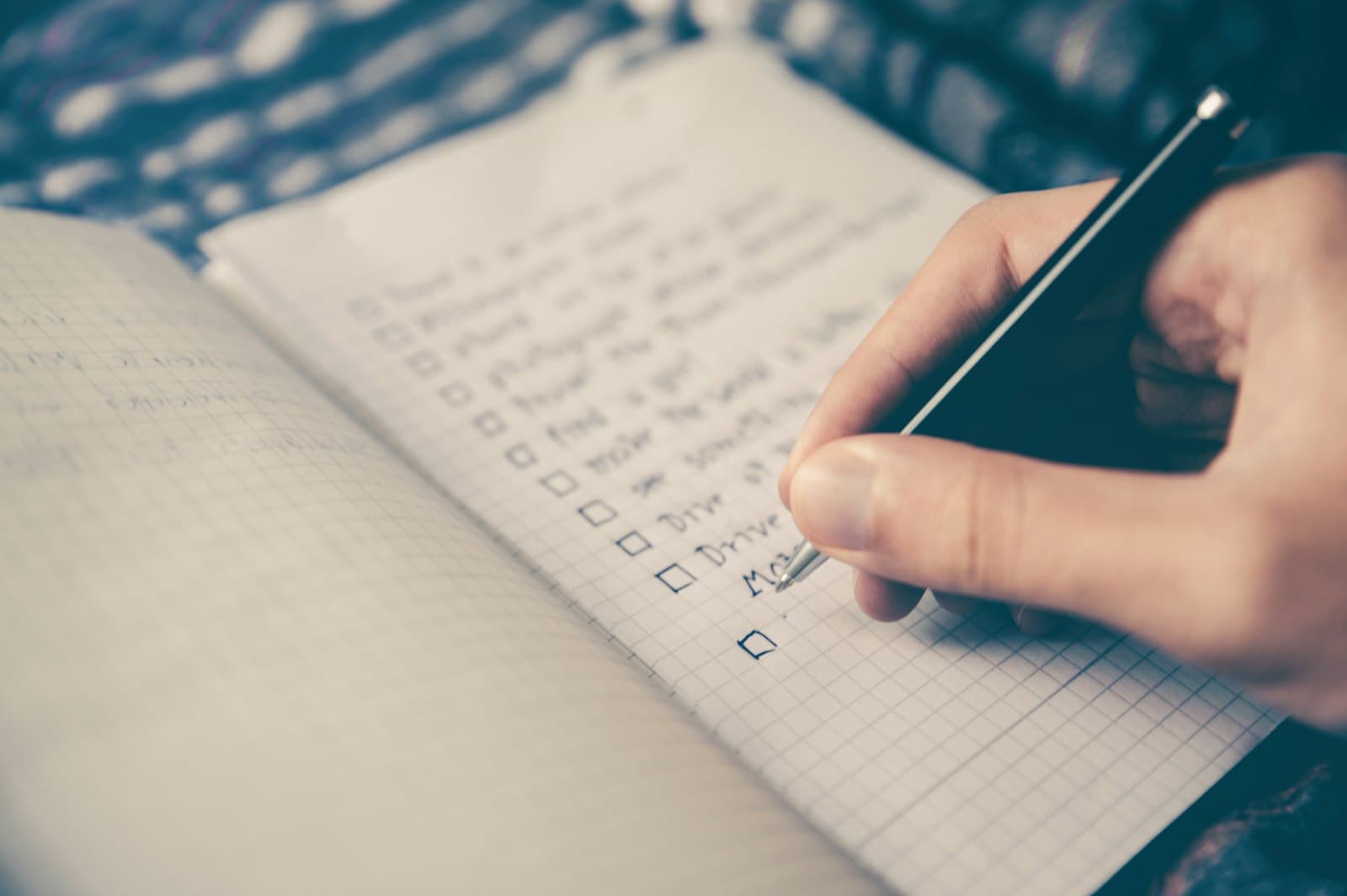 Persona repasando una lista de comprobación en una libreta antes de un evento