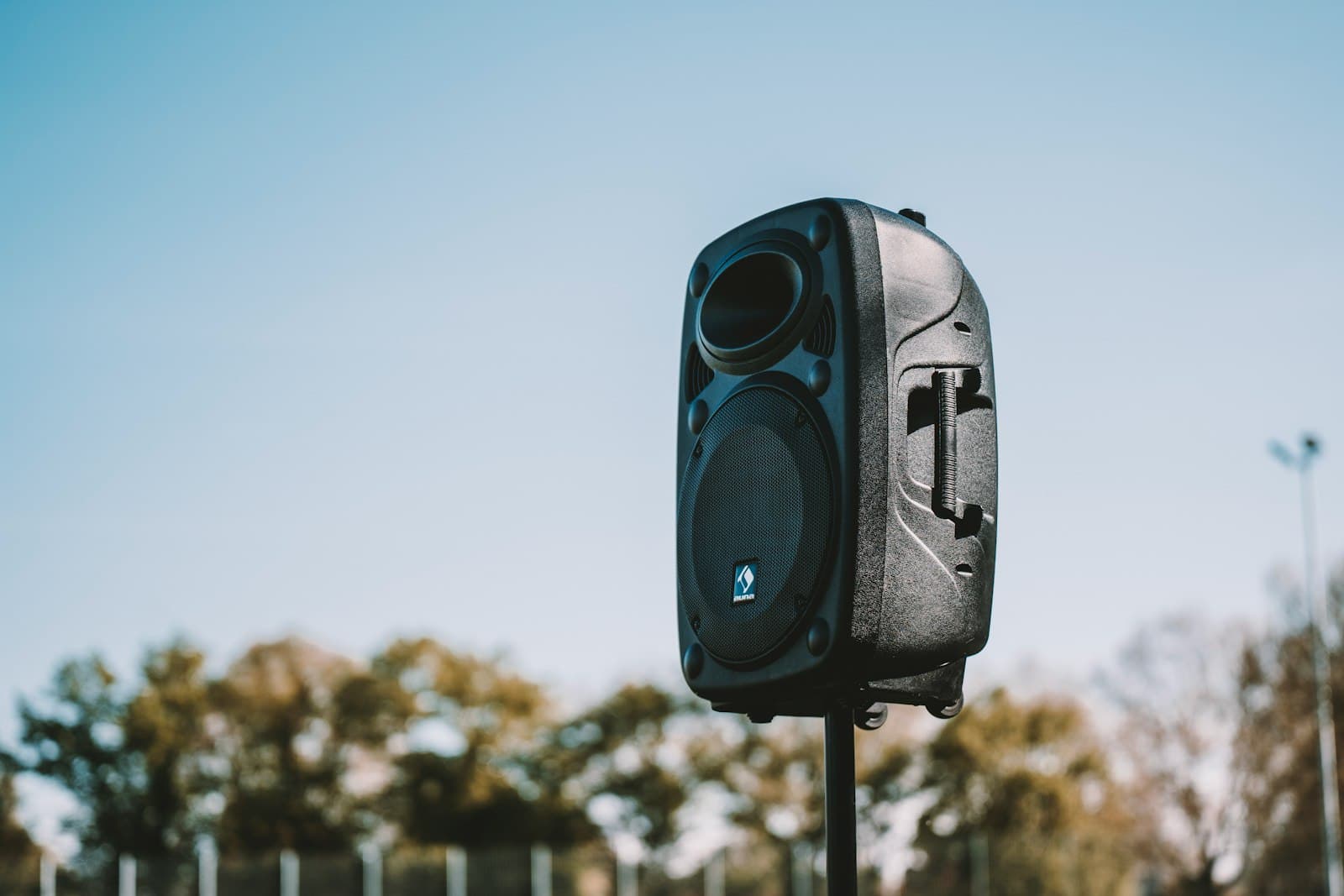 Altavoces elevados sobre trípodes a ambos lados de una pista de baile