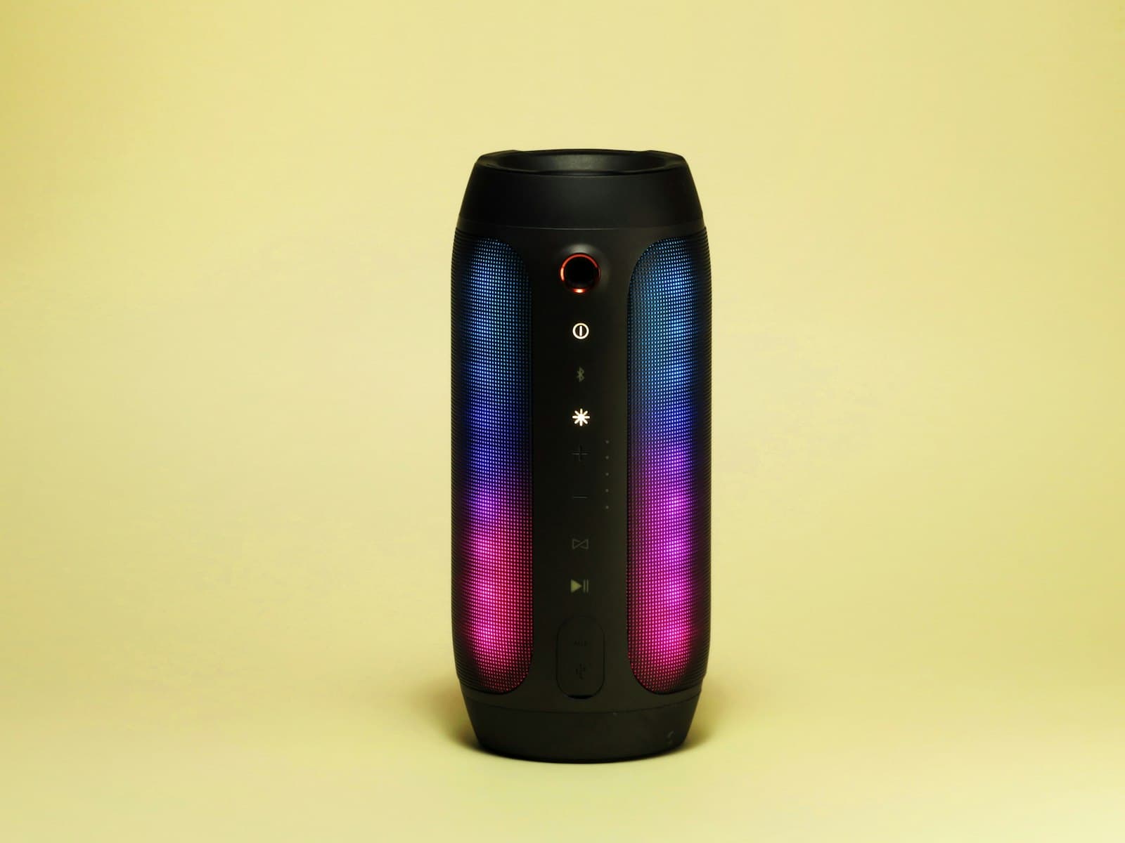 Columna de sonido activa instalada en el lateral de una sala de fiesta con luces de colores al fondo