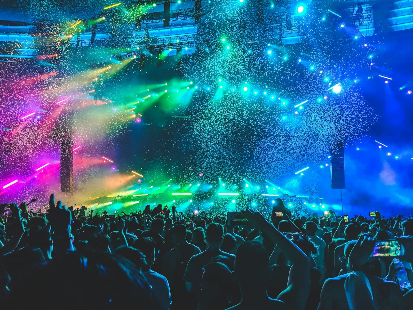 Luces de colores reaccionando al ritmo de la música sobre una pista de baile llena
