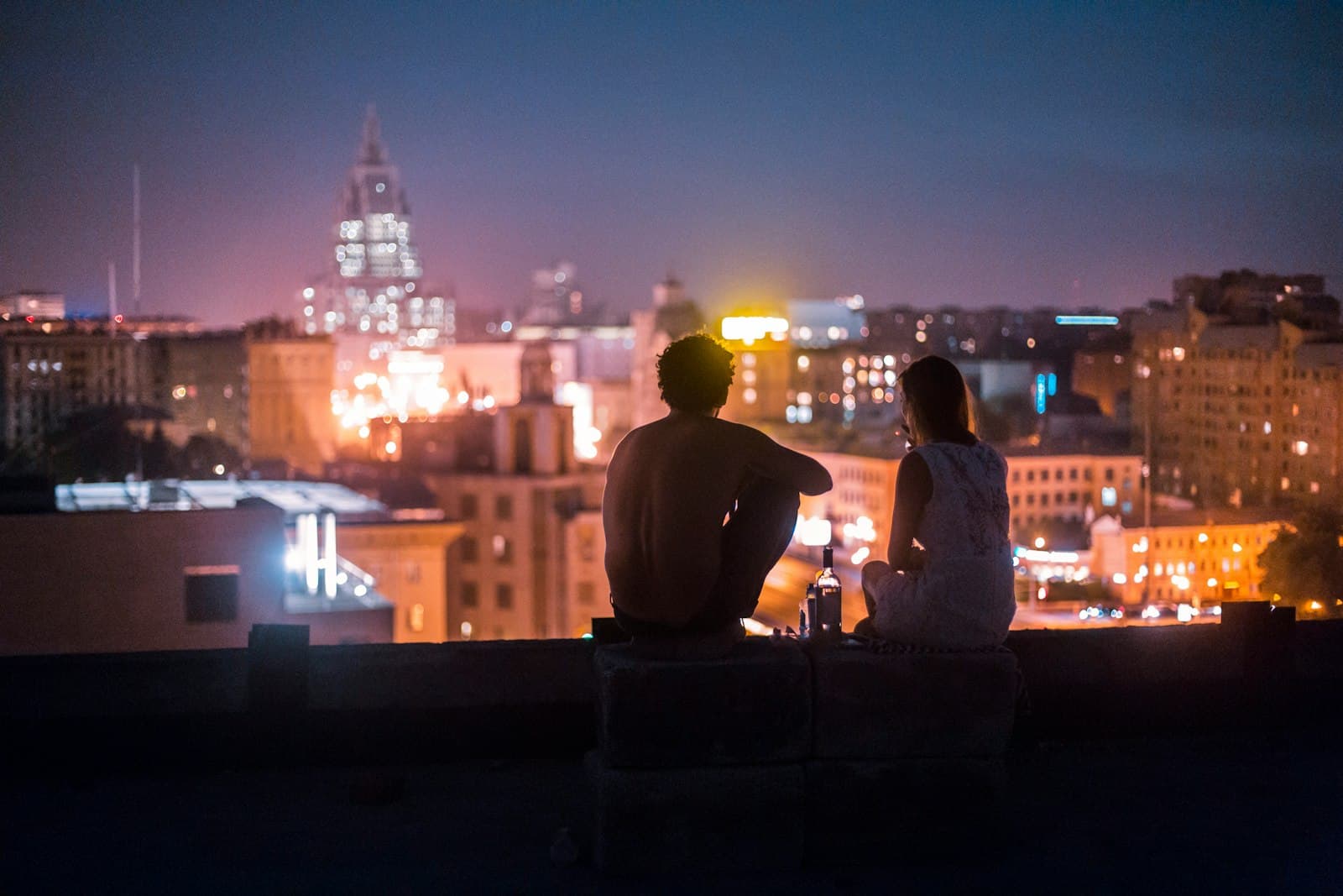 Rooftop de oficina en Barcelona a última hora con copas, conversación y un altavoz de columna al fondo