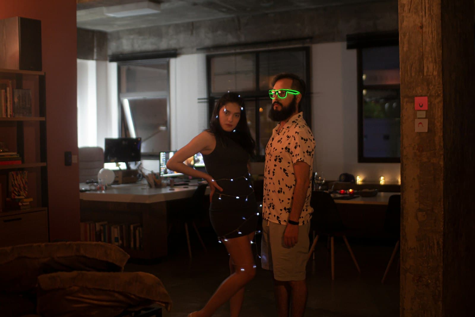 Ático de Barcelona de noche con amigas bailando y luces LED de colores sobre un altavoz de columna