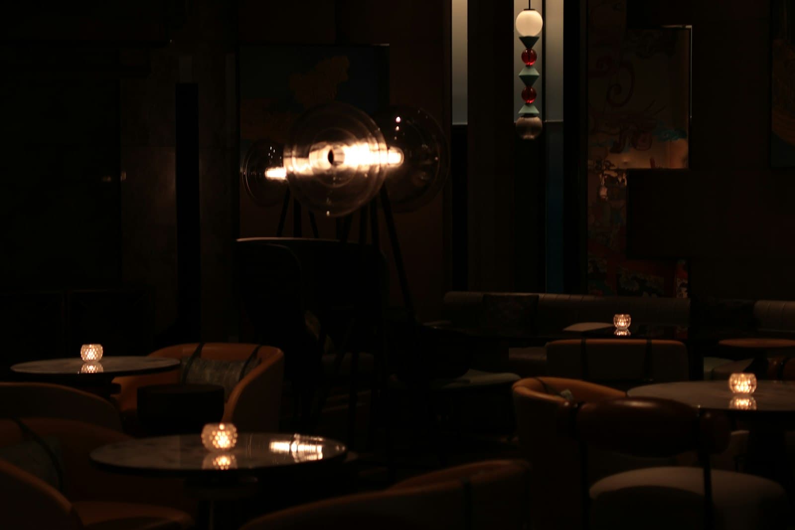 Copas de cóctel en una recepción con luz ambiente y un altavoz discreto al fondo
