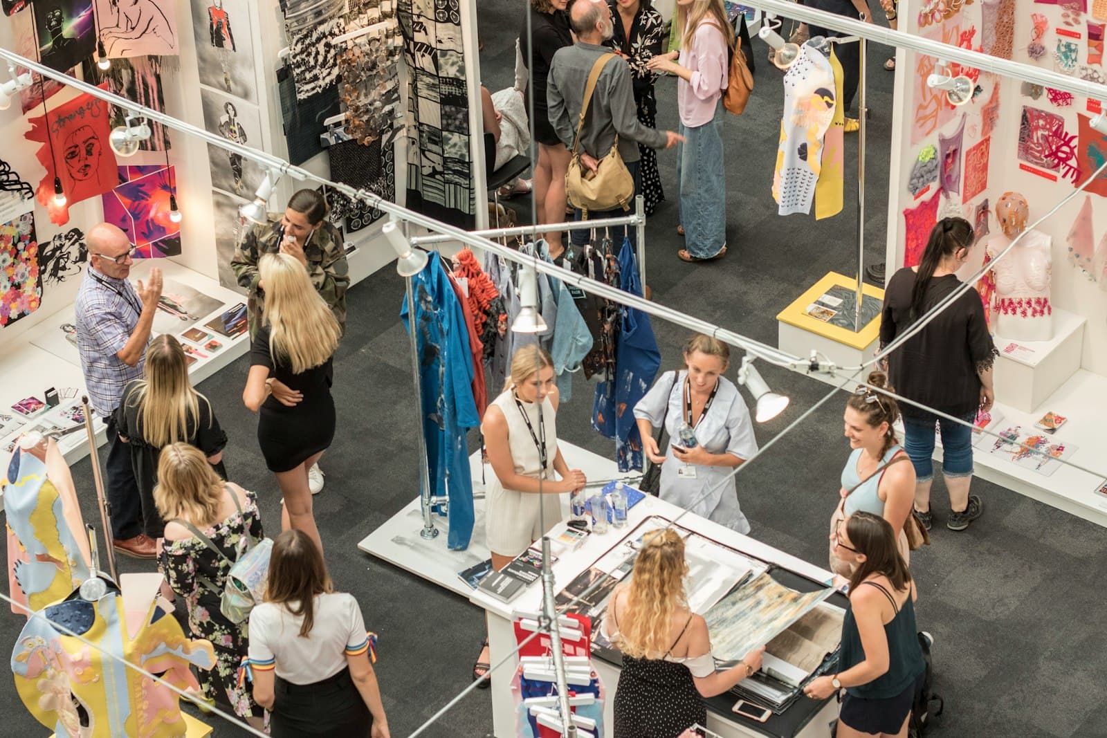 Interior de pop-up store con ropa, una mesa de caja y un altavoz compacto junto a una toma